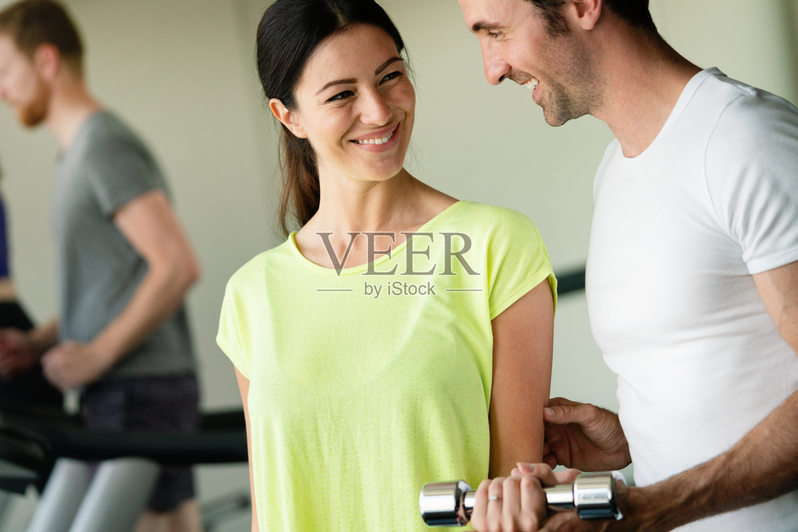 帮助女性练习哑铃的私人教练照片摄影图片