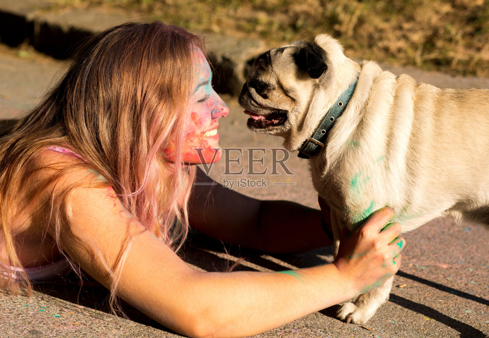 快乐的年轻女子满身胡里粉和毛茸茸的小狗摆姿势照片摄影图片