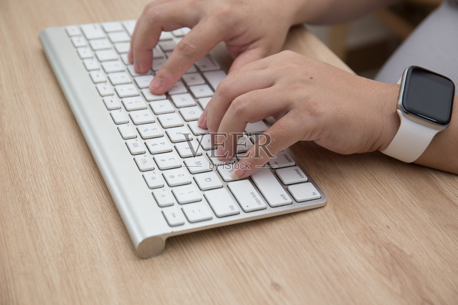 女性的手在无线键盘上打字的特写照片摄影图片