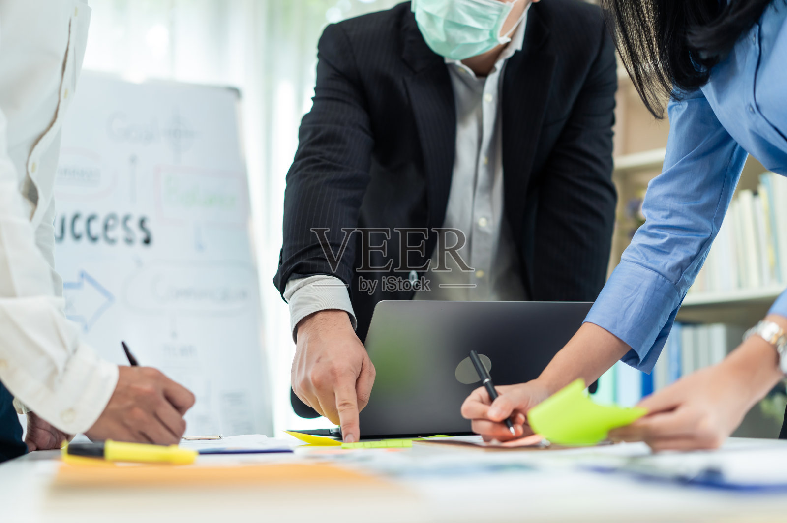 商务人士因新冠肺炎戴口罩，在办公室开会。男员工和女员工进行头脑风暴和团队合作，讨论和计划公司项目。公司的现代同事或同事。照片摄影图片