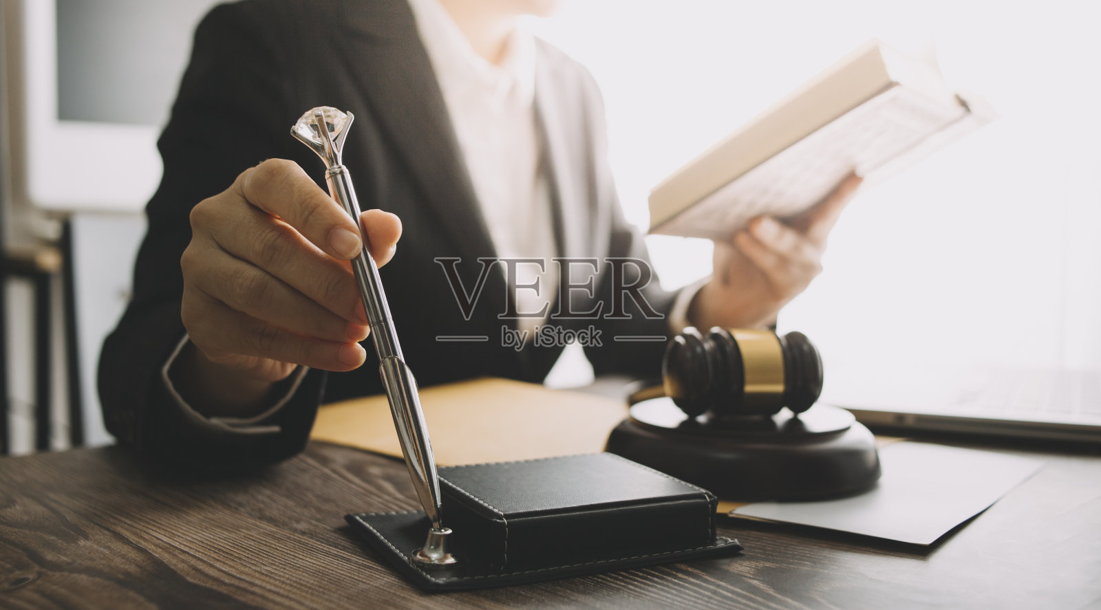 商务人士与律师在办公室讨论合同文件，桌面有黄铜天平。法律、法律服务、建议、公正和法律概念。照片摄影图片