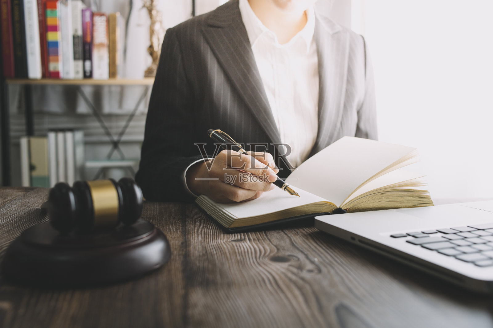 商务人士与律师在办公室讨论合同文件，桌面有黄铜天平。法律、法律服务、建议、公正和法律概念。照片摄影图片