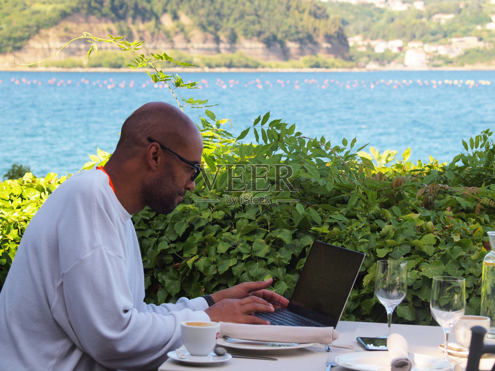 一个人在海边度假，用笔记本电脑工作照片摄影图片