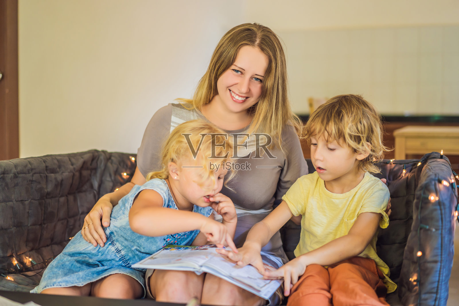 教师，家庭教师，男孩和女孩在餐桌上上学。或者母亲，女儿和儿子。在家教育照片摄影图片