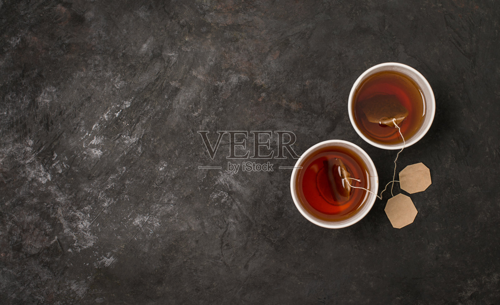 两个棕色纸杯和热茶在黑色背景和副本空间。照片摄影图片