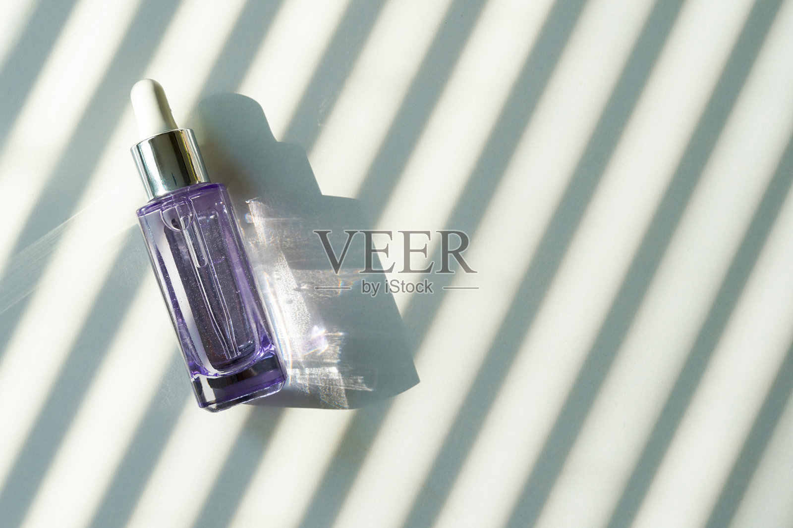 含胶原蛋白和多肽的抗衰老血清，玻璃瓶滴液，白色背景，有阴影。抗衰老产品，奢华身体护理和有机科学理念。照片摄影图片