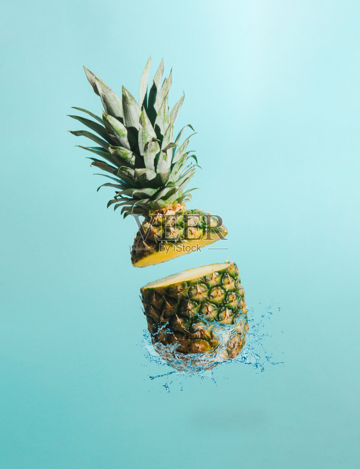 切片的菠萝和水溅在柔和的蓝色背景。最小的水果的概念。夏季热带的想法。照片摄影图片