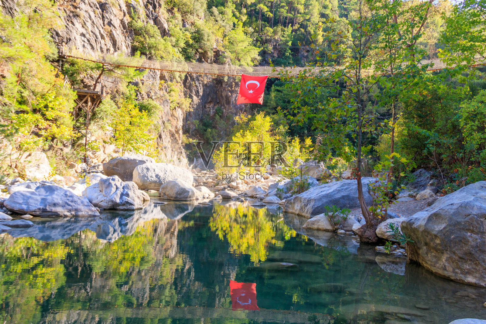 土耳其安塔利亚省戈伊努克峡谷的吊桥上悬挂着一面土耳其国旗照片摄影图片