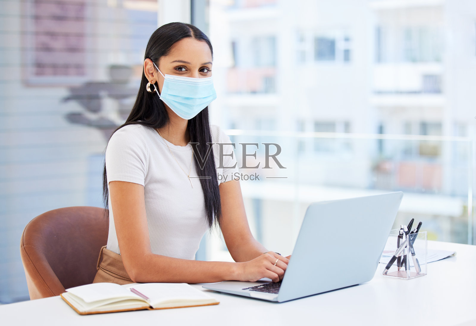 这是一个年轻的女商人在工作中使用笔记本电脑的照片照片摄影图片