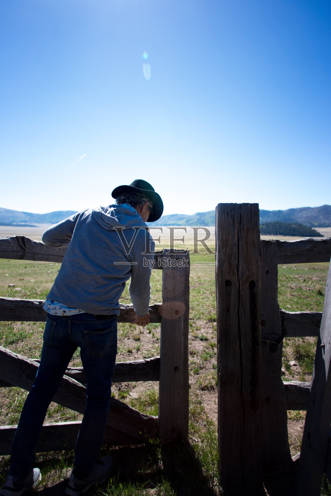 牛仔举着老式的牧场栅栏门照片摄影图片