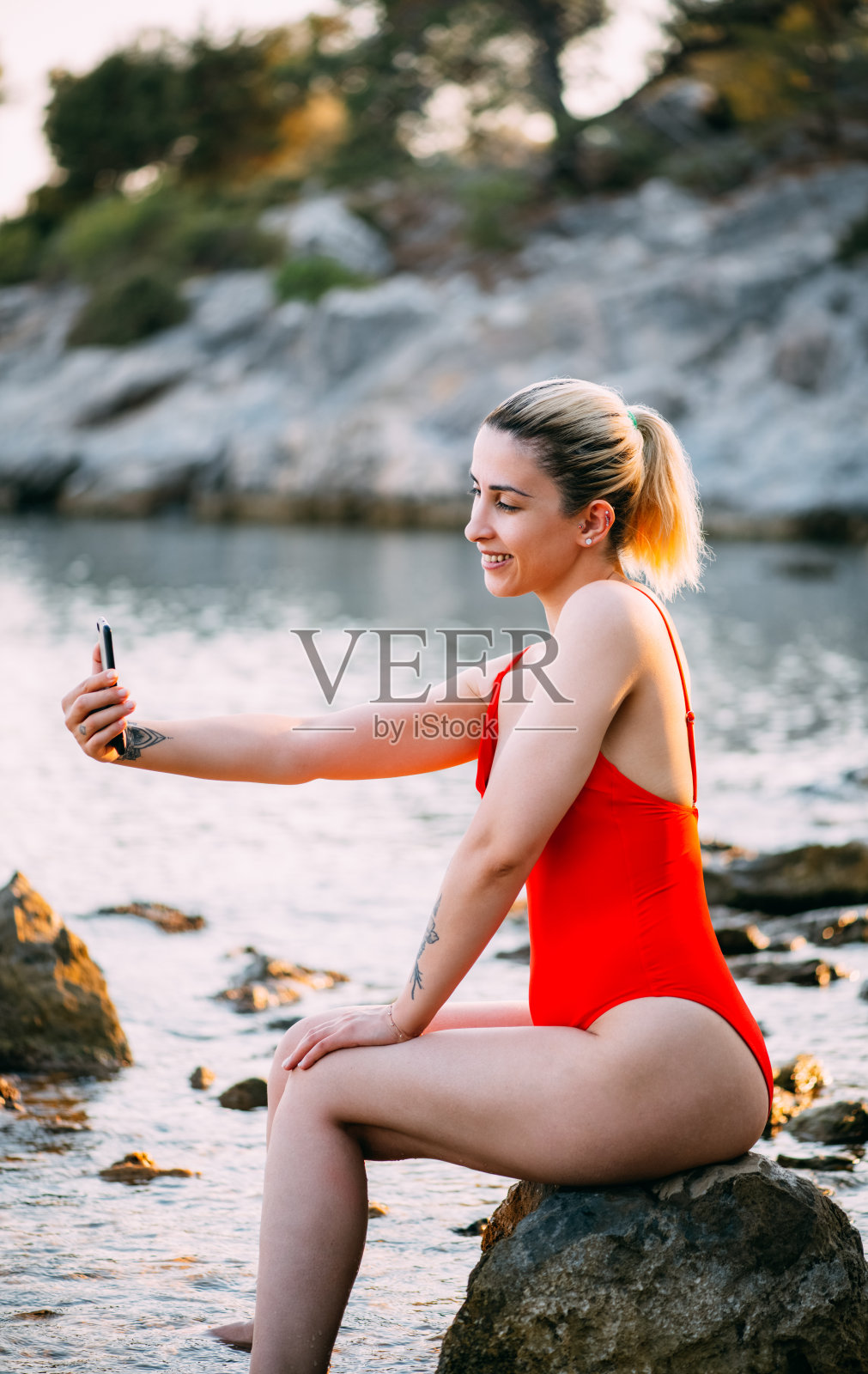 穿着红色泳衣的女人在沙滩上自拍照片摄影图片