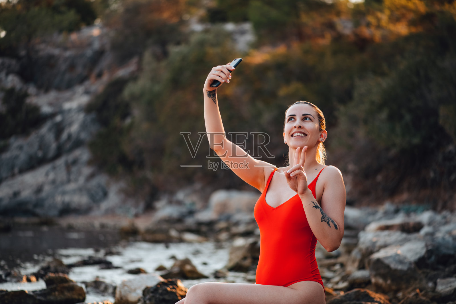 穿着红色泳衣的女人在沙滩上自拍照片摄影图片