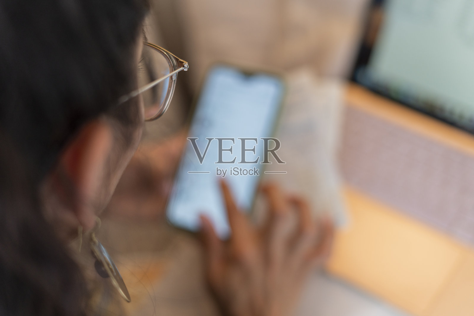 女人坐在沙发上用手机和笔记本电脑理财照片摄影图片