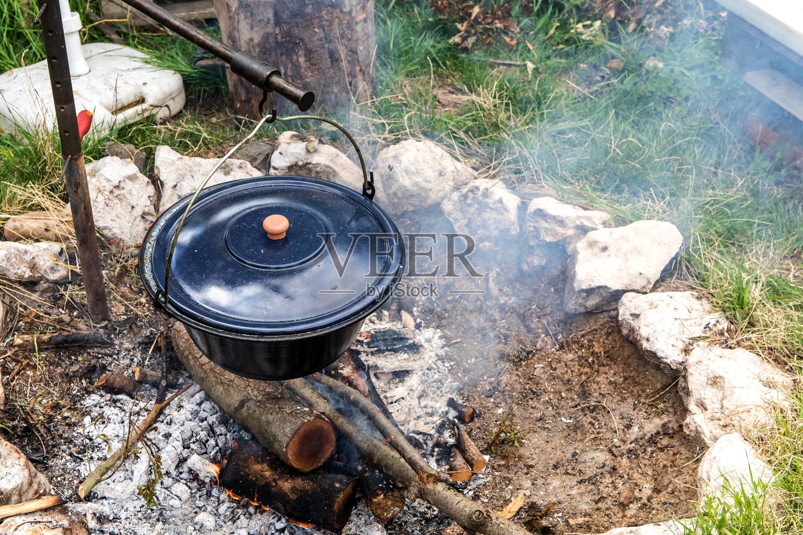 金属大锅在篝火上沸腾。用篝火做饭，野营餐。篝火上炖牛肉的传统做法照片摄影图片