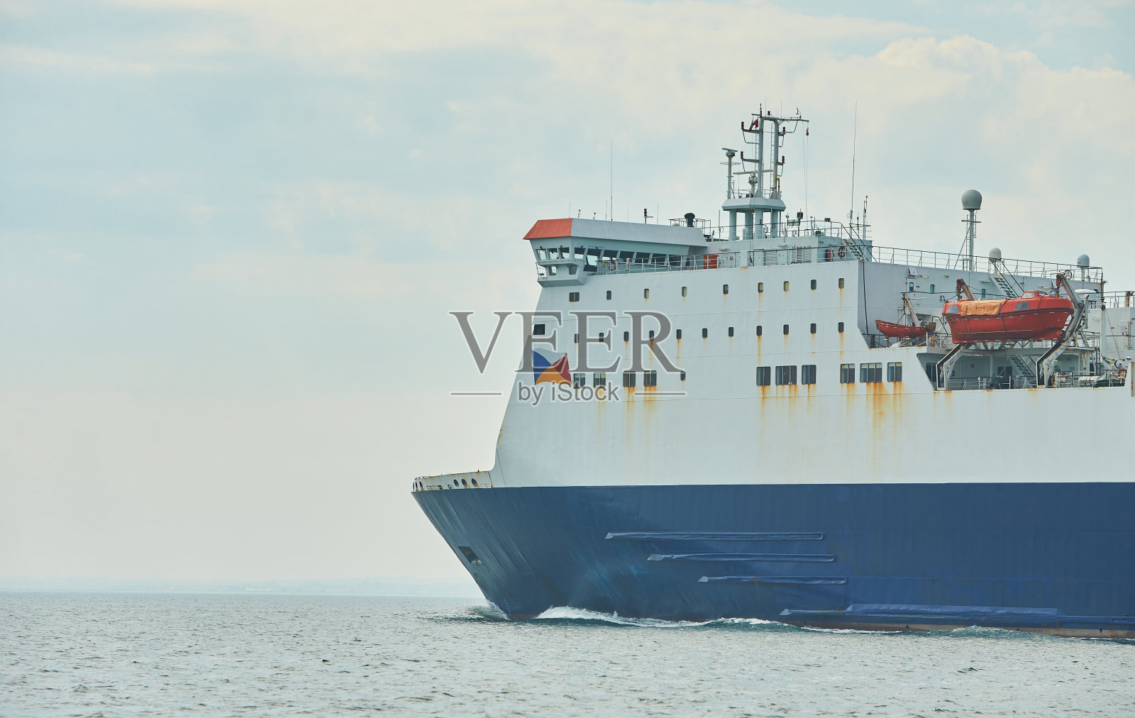 巨大的集装箱油船载着卡车大小的五颜六色的集装箱在深蓝色的开阔的海洋照片摄影图片