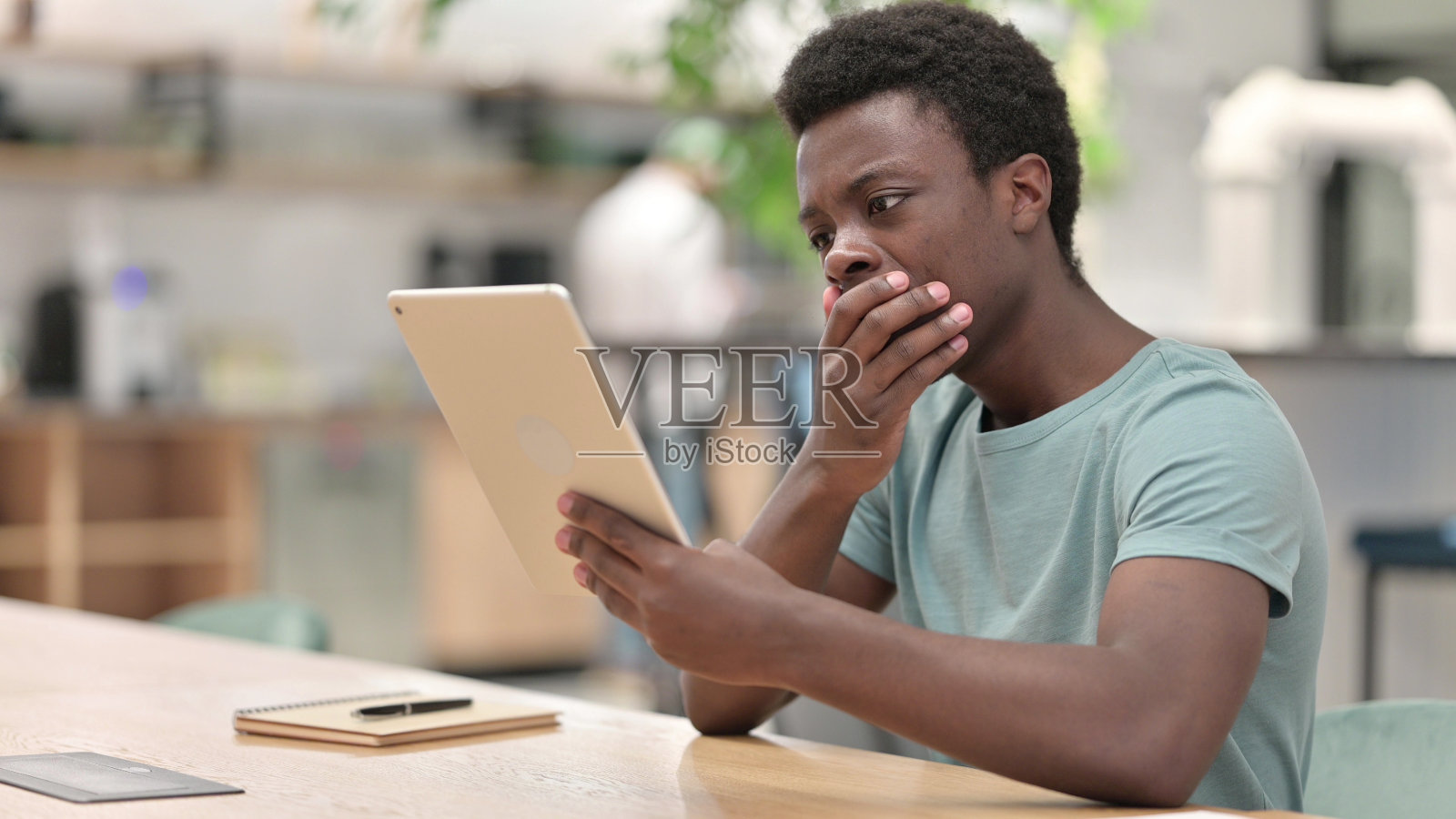 年轻非洲男子对平板电脑上的损失做出反应照片摄影图片