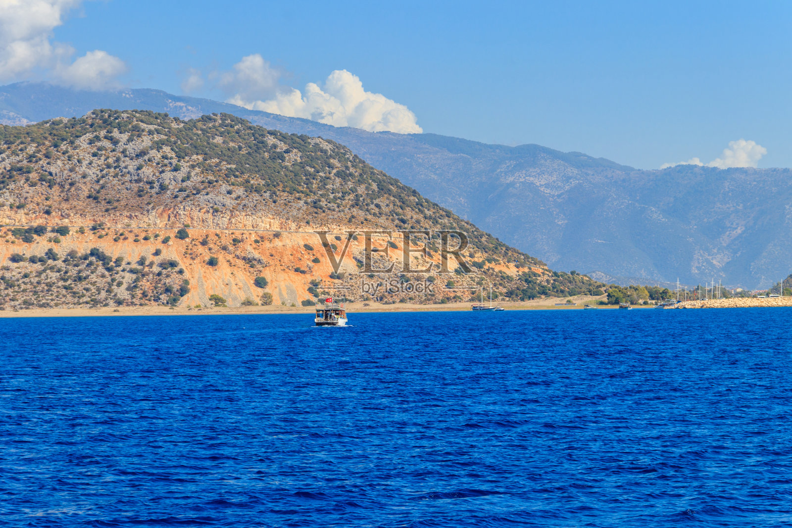一艘旅游船在土耳其安塔利亚省凯科娃岛附近的地中海上航行。土耳其的里维埃拉照片摄影图片