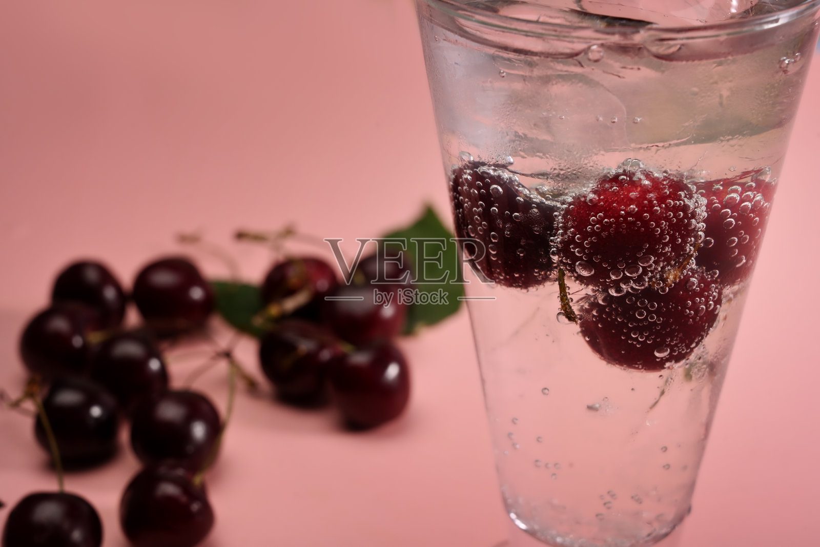 粉色背景下的樱桃苏打饮料。照片摄影图片
