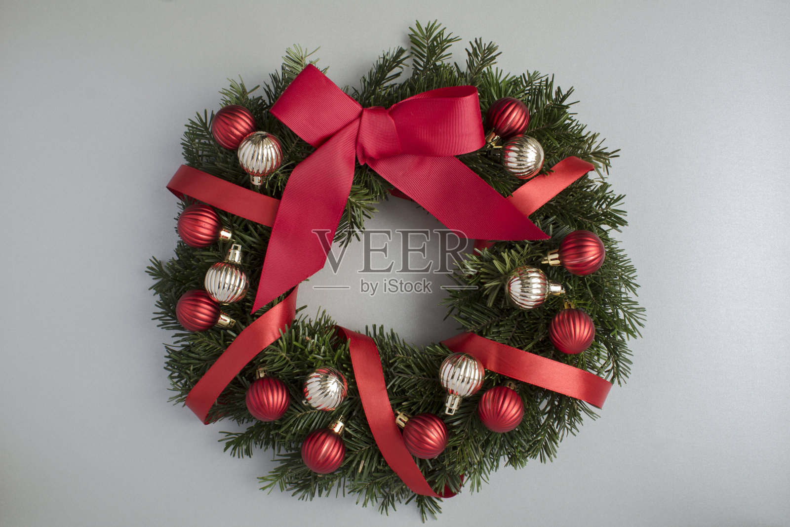 在灰色背景上镶有红色和金色小球的圣诞戒指或花环。前视图。特写镜头。照片摄影图片