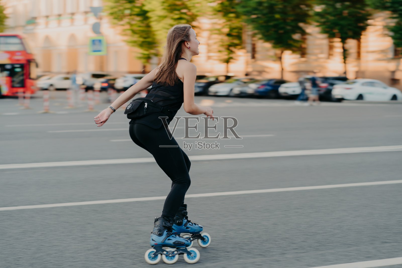积极的生活方式和爱好观念。运动的年轻女子做运动户外骑，滑旱冰，穿着运动服，享受健身活动pose在城市的地方的道路上。机器人前进。照片摄影图片