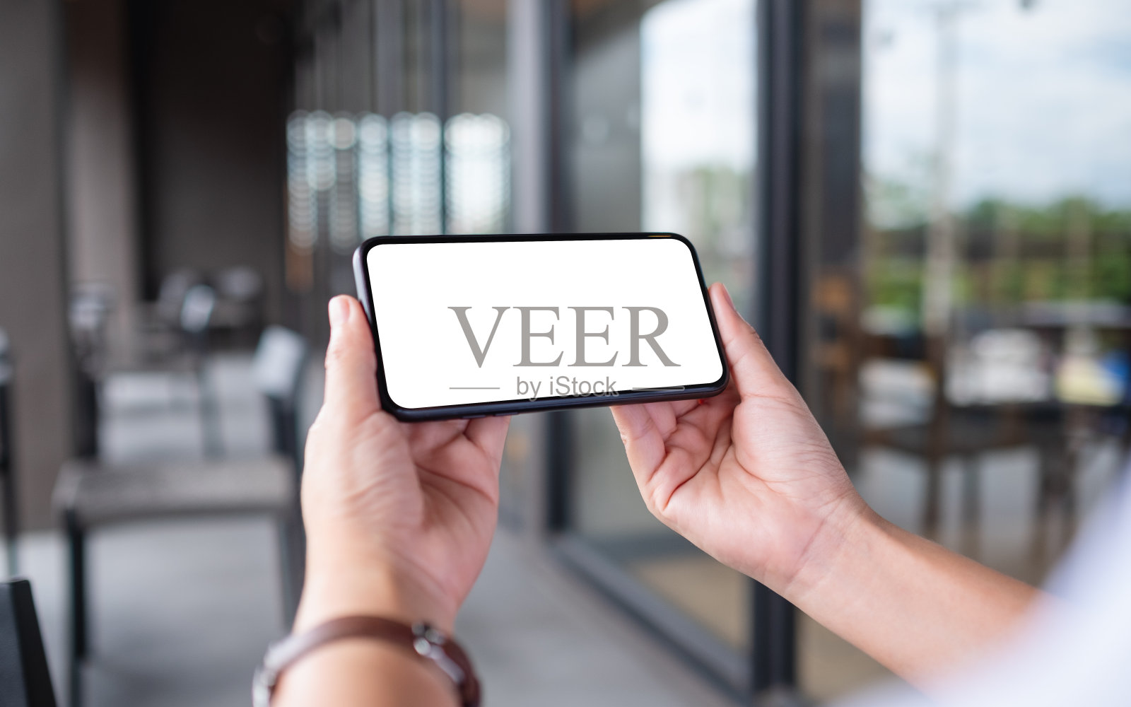 一个女人拿着手机和空白的白色桌面屏幕照片摄影图片