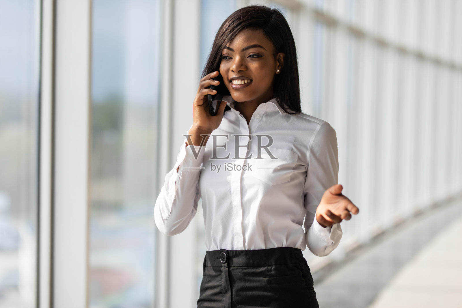 漂亮的非裔美国人办公室职员在办公室打电话照片摄影图片