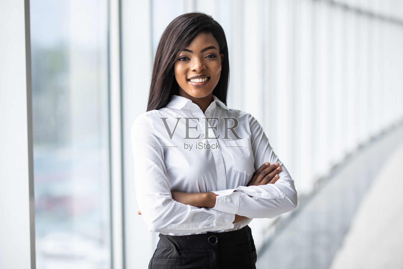 年轻的非洲女商人在办公室里向窗外看照片摄影图片