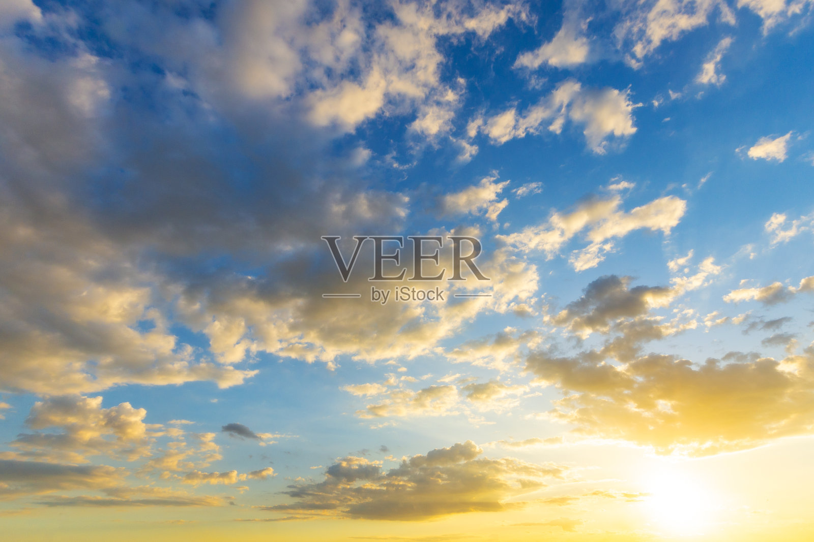 天空中蓝色和橙色的阳光透过天空中的云朵照片摄影图片