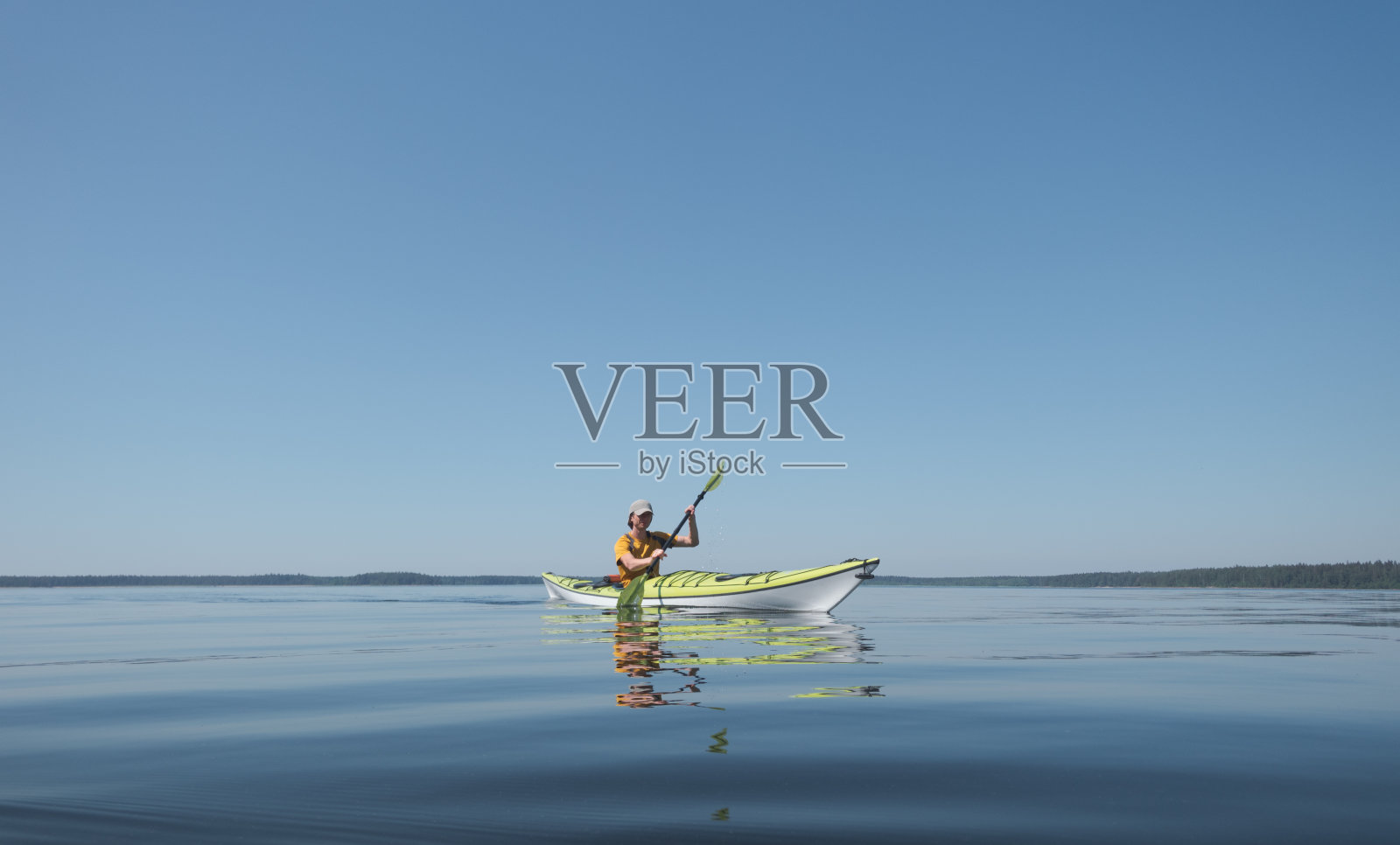 在阳光明媚的日子里在平静的水面上划皮艇照片摄影图片