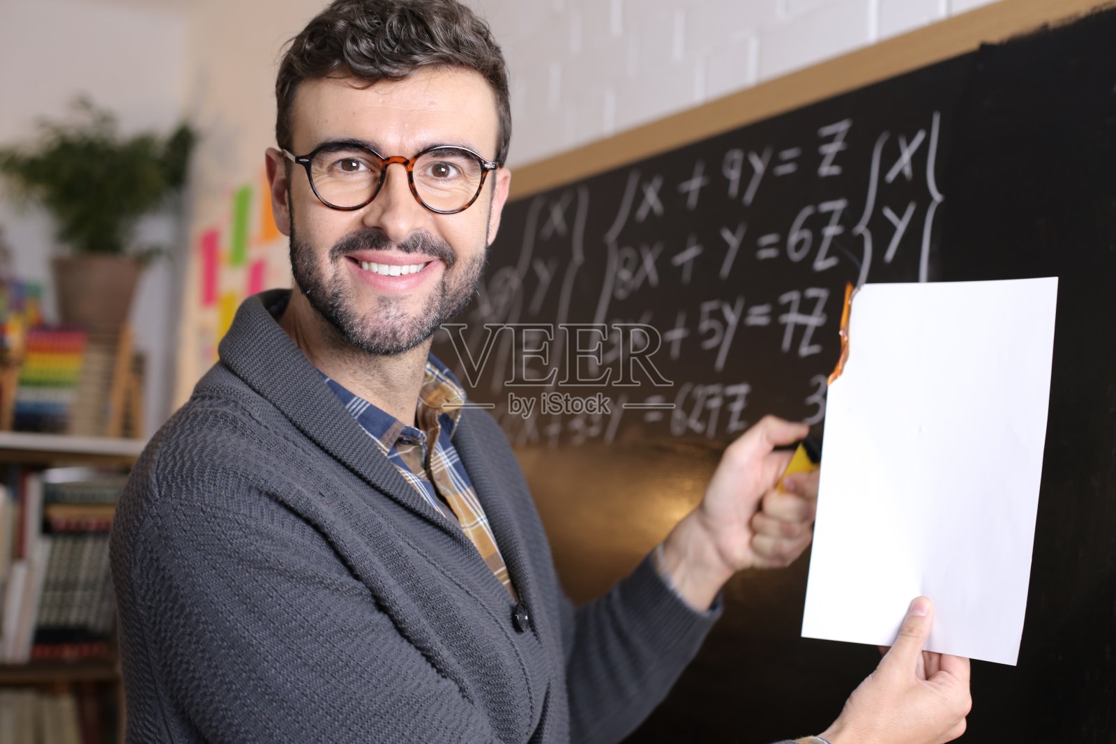 老师在教室里拿着火的白纸照片摄影图片