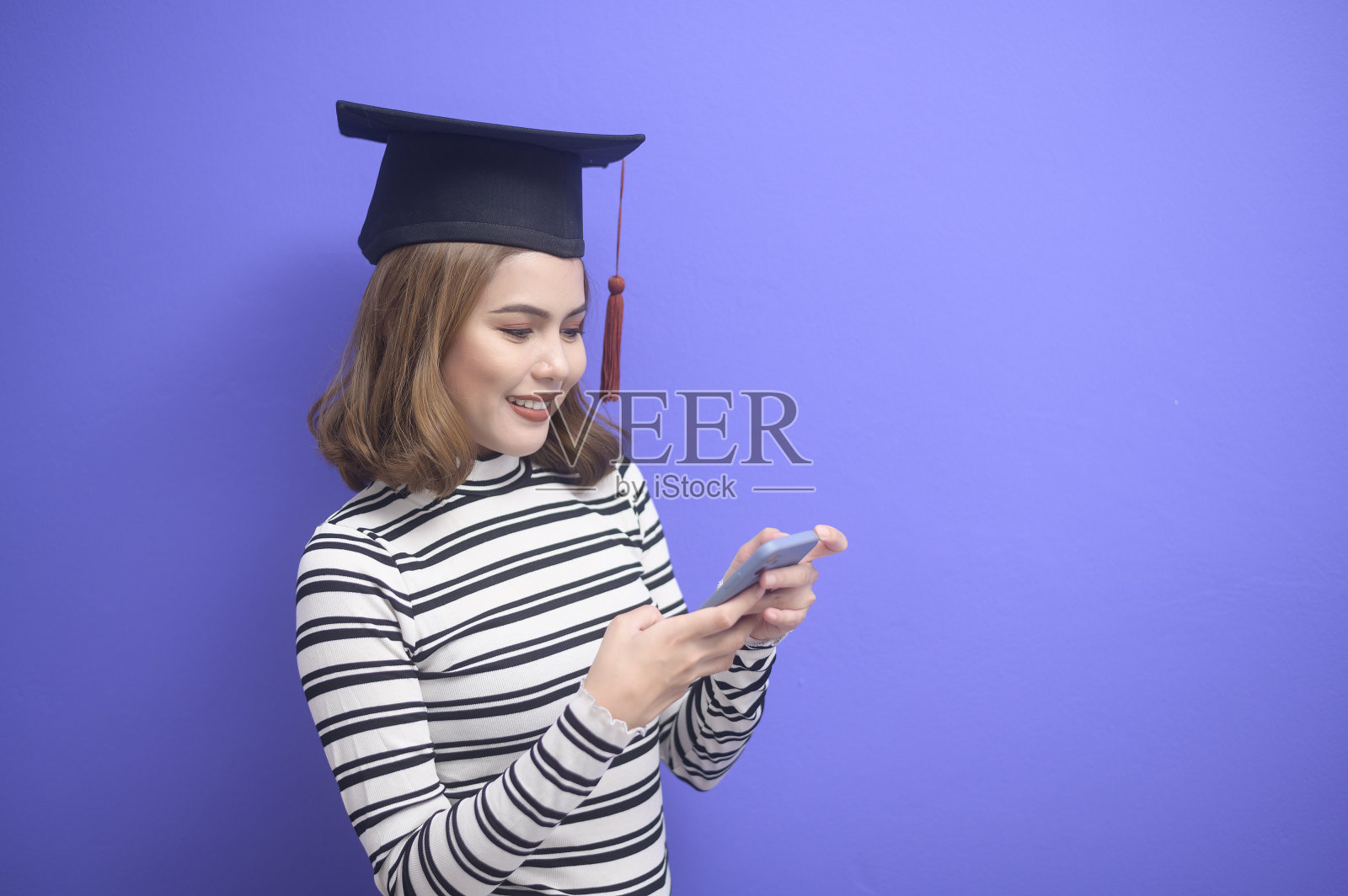 蓝色背景下的年轻女子毕业画像照片摄影图片