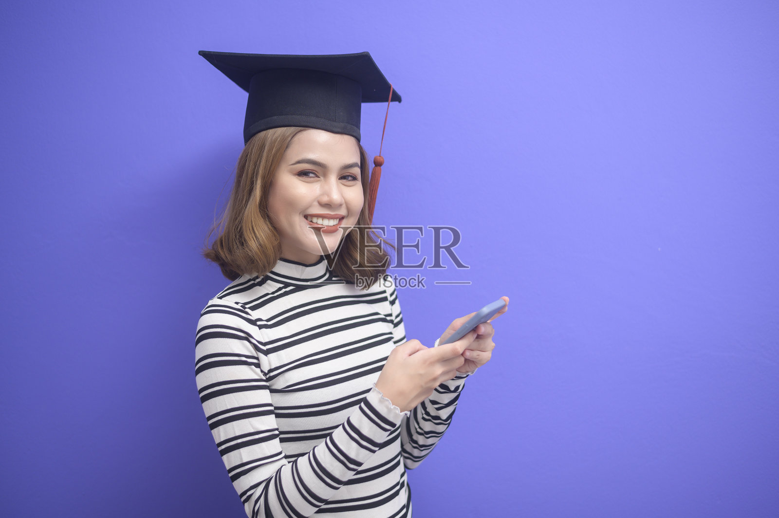 蓝色背景下的年轻女子毕业画像照片摄影图片