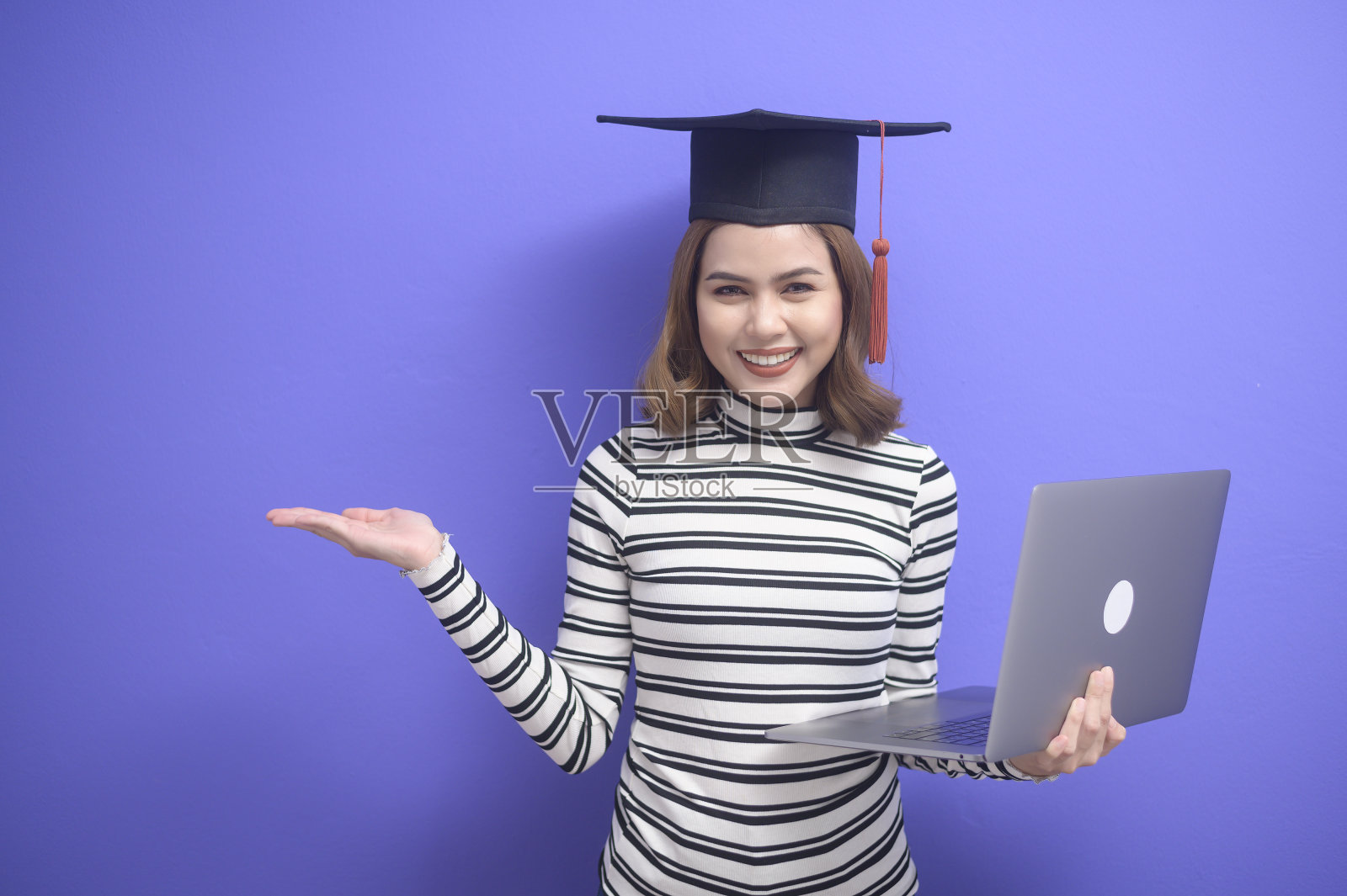 蓝色背景下的年轻女子毕业画像照片摄影图片