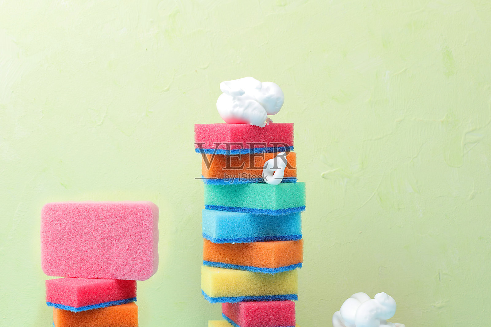 彩色海绵用于在阳光充足的房间里洗碗和清洁。室内清洁的概念照片摄影图片