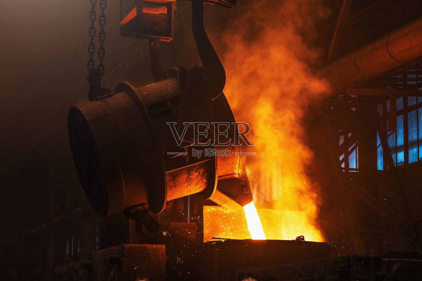熔融金属铸造。在铁中注入烟雾和火花。冶金工厂。钢铁生产。铸造高炉照片摄影图片