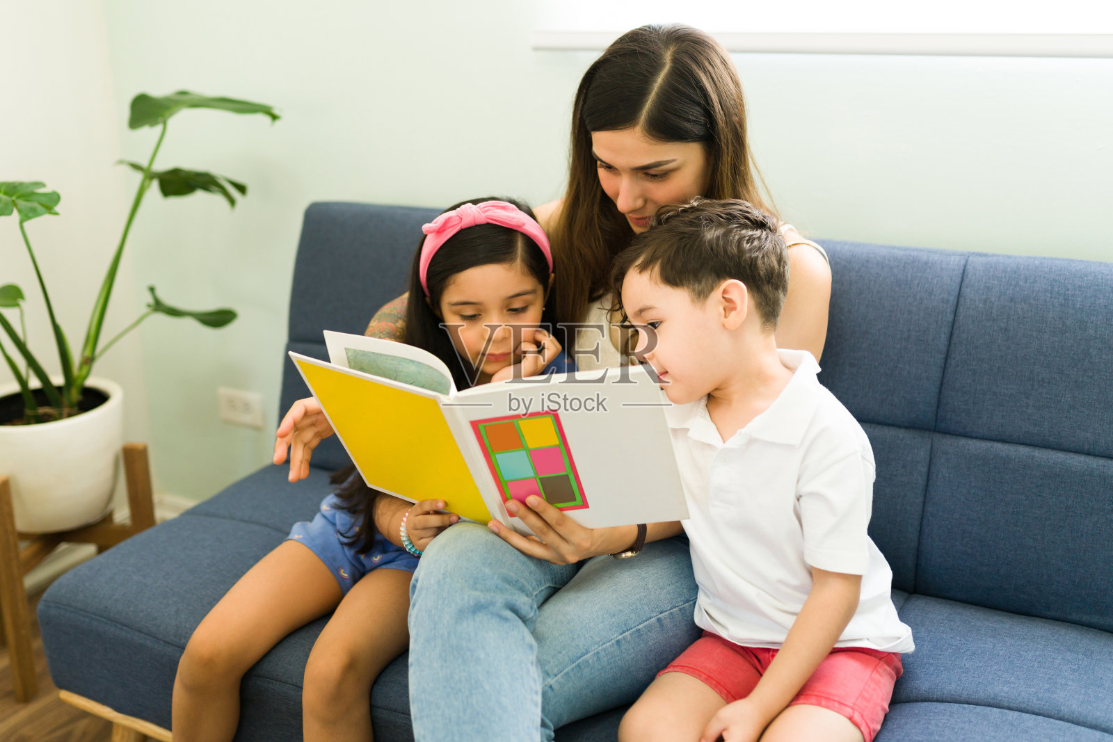 为她的儿子和女儿读儿童故事照片摄影图片