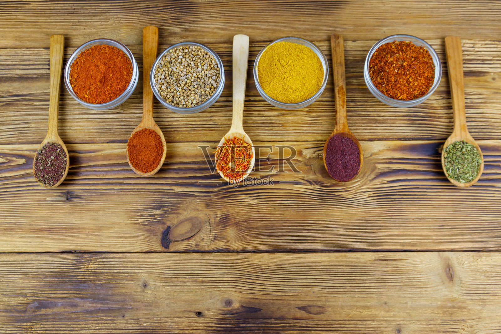 木桌上放着不同的香料。俯视图，复制空间照片摄影图片