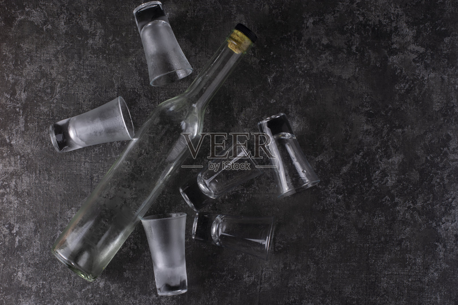 一瓶伏特加和六个空杯子。从以上观点。照片摄影图片