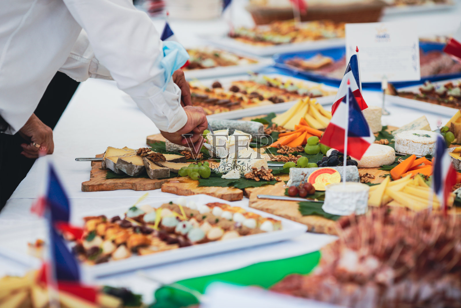 浅景深(选择性聚焦)的图像，人们从一张桌子上吃法国菜开胃酒。照片摄影图片