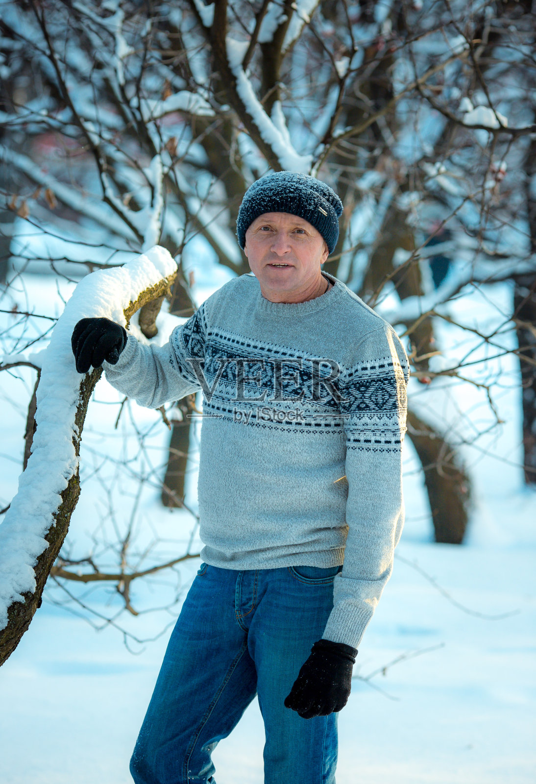 一个男人在一个下雪的日子里在森林里的肖像。那个穿冬季运动装的家伙。照片摄影图片