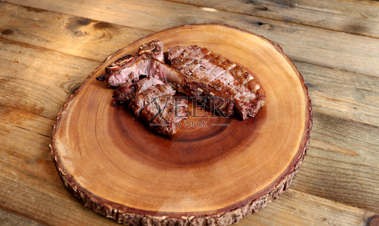 牛排t -骨烤在烤架上与骨头和两种肉。木制背景照片摄影图片