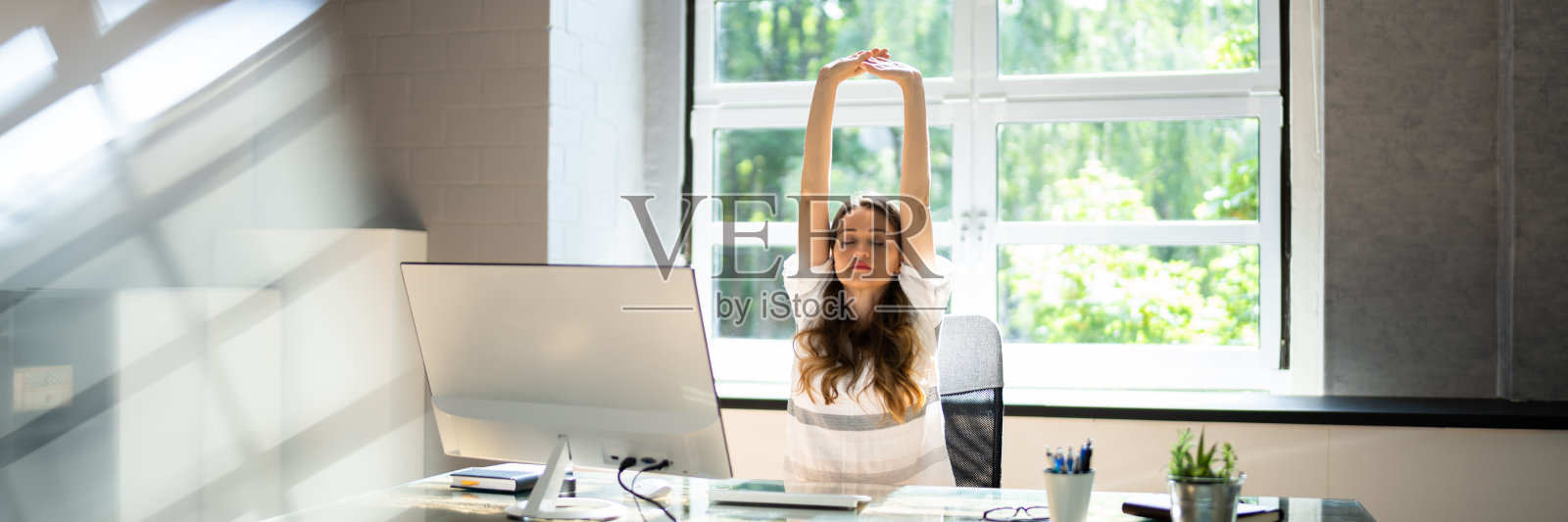 在办公室做伸展运动。女人照片摄影图片