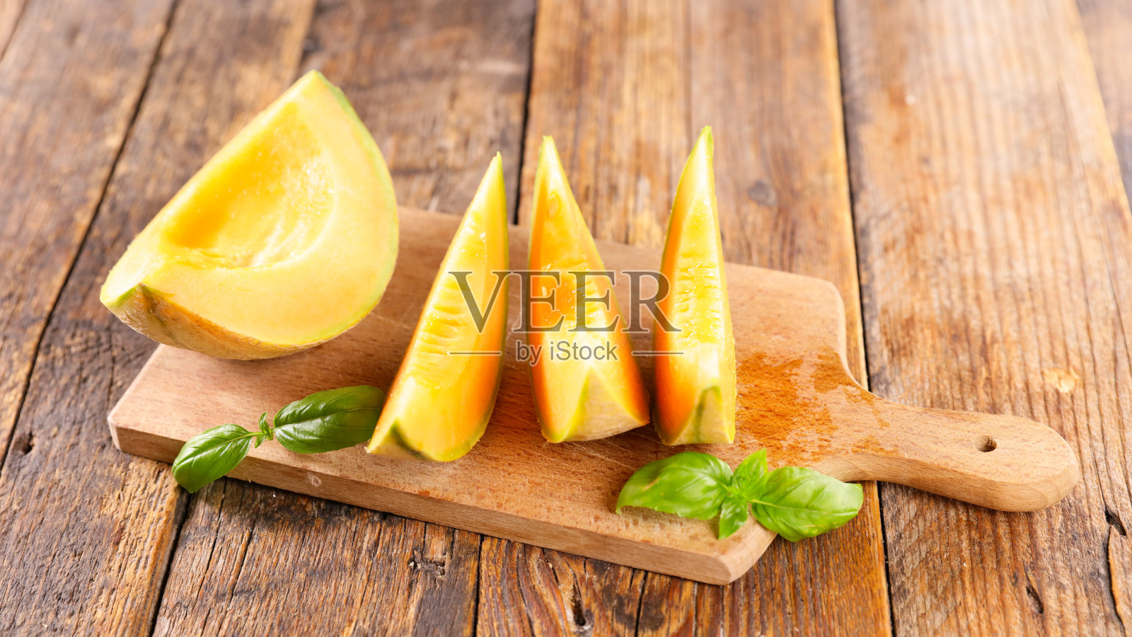 鲜甜瓜切片放在木板上照片摄影图片