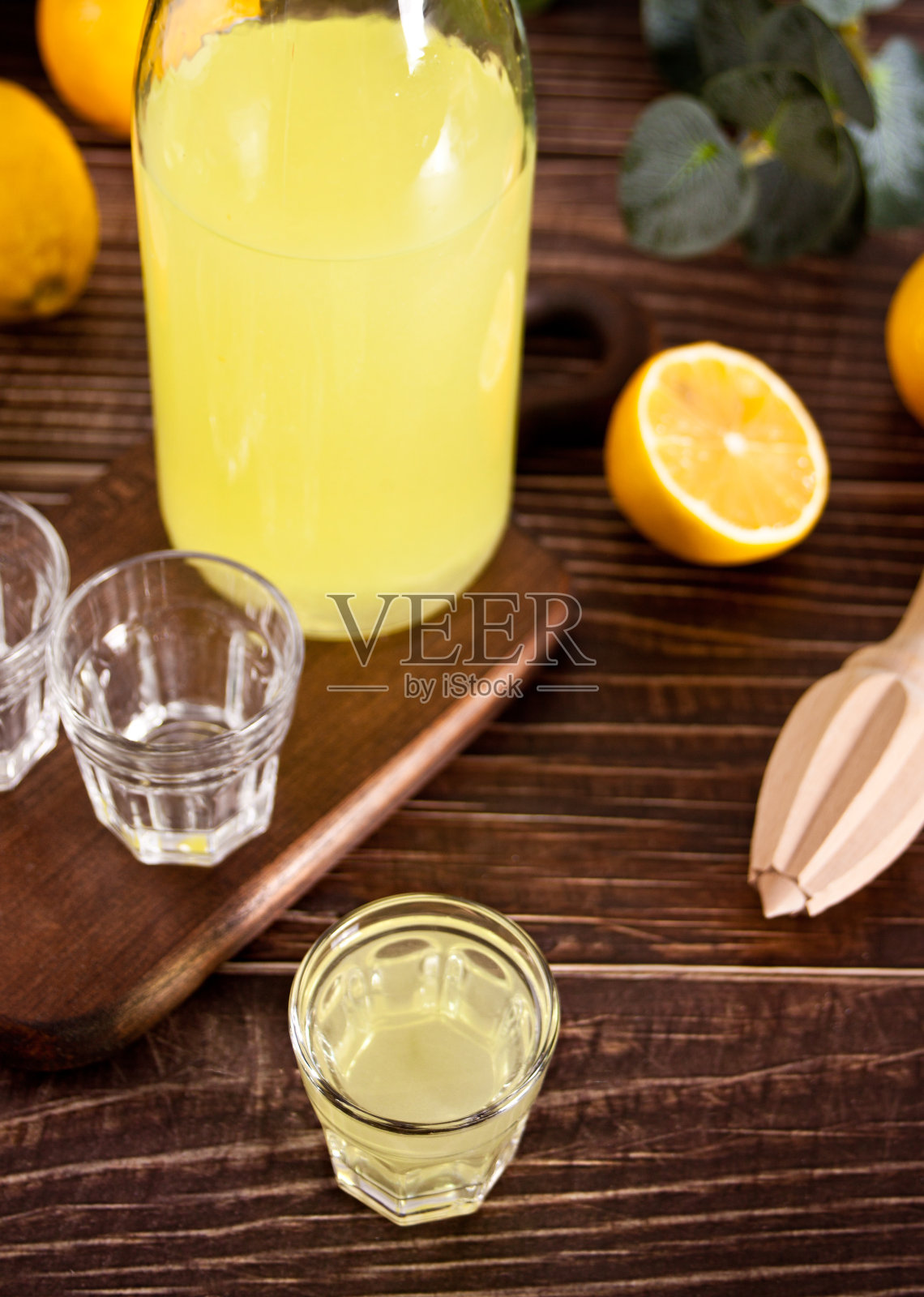 意大利柠檬利口酒柠檬酒在一个瓶子和空杯子在木桌上照片摄影图片
