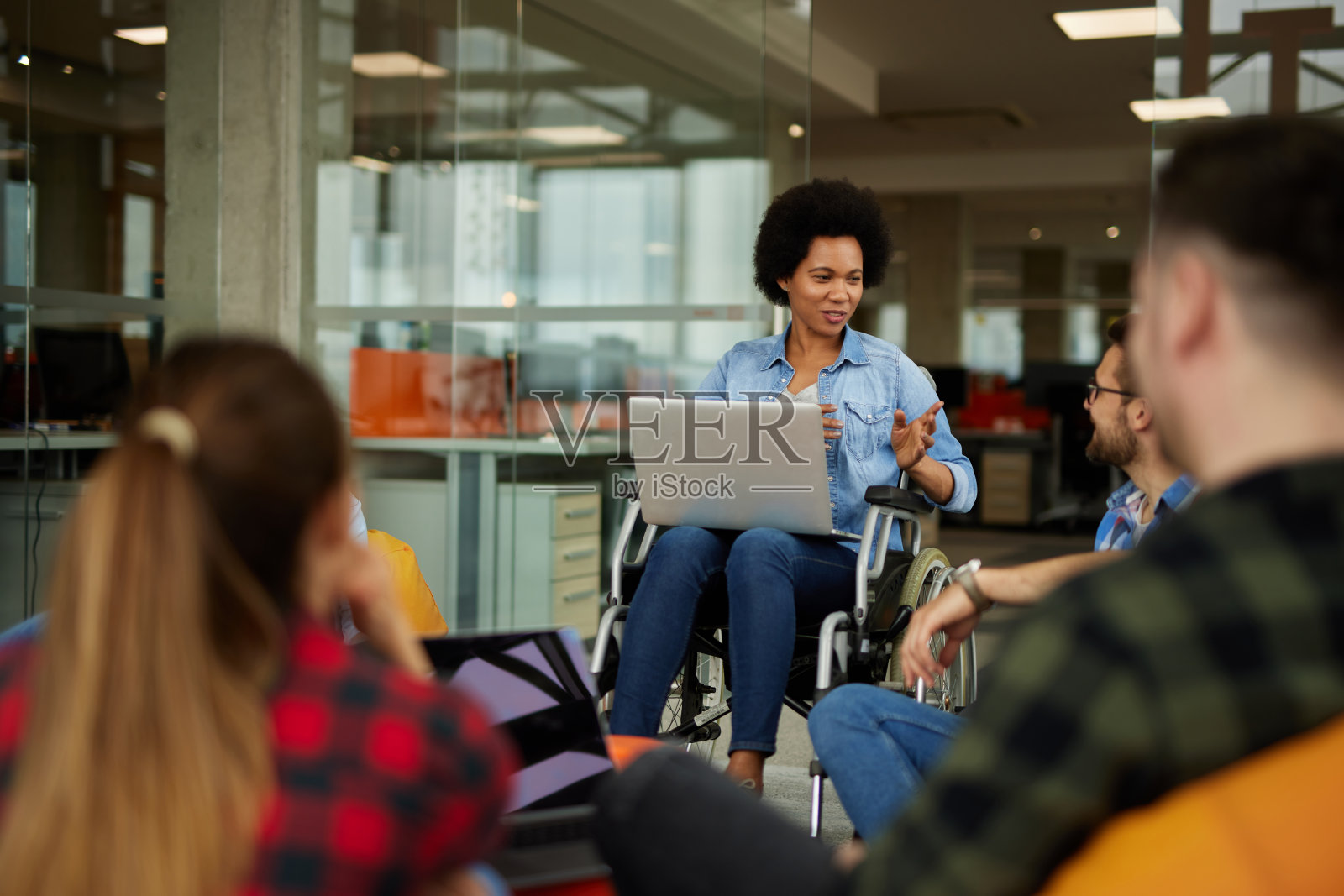 残疾女商人在办公室与同事讨论照片摄影图片