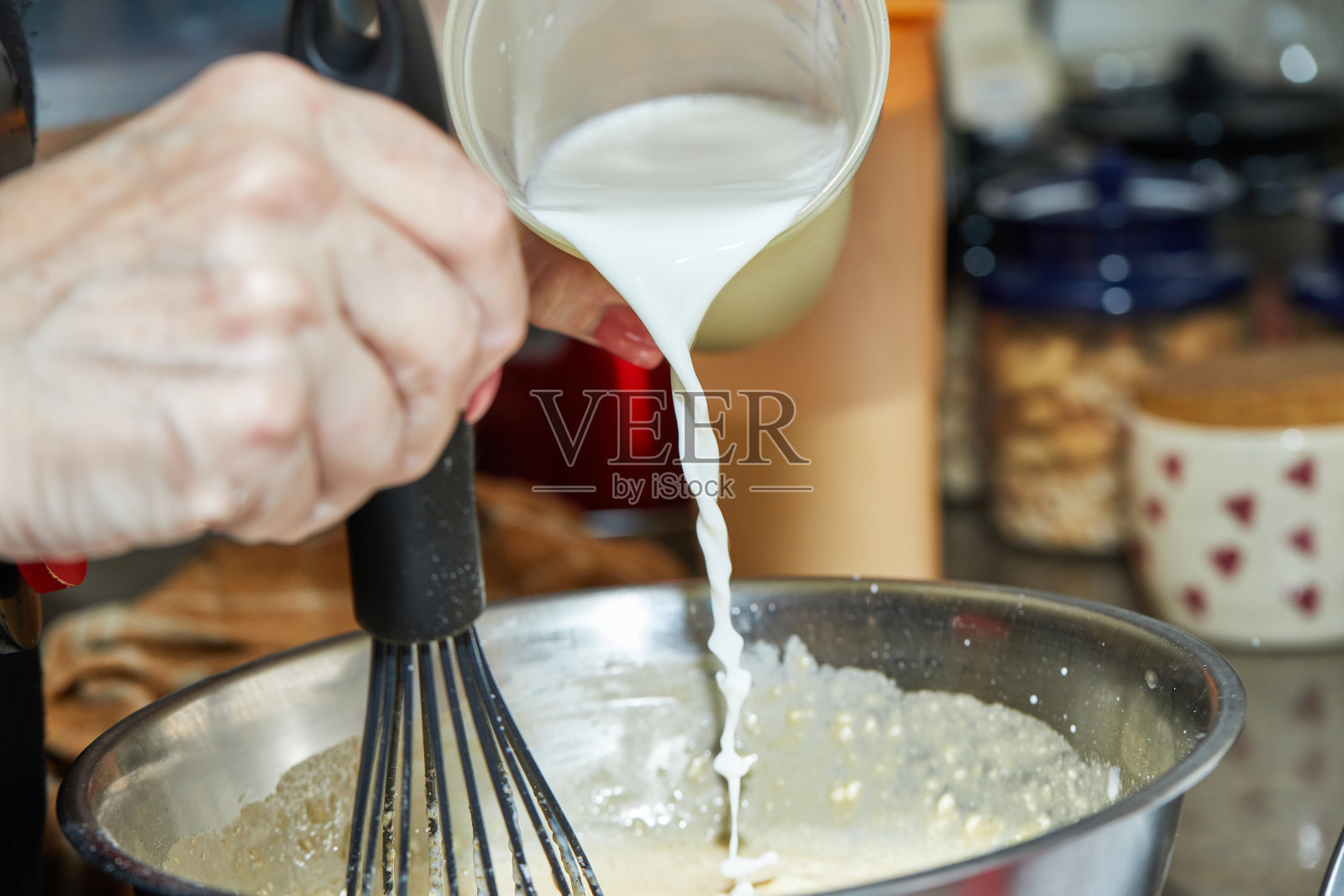 厨师将牛奶倒入面团碗中，制作芦笋和豌豆烘焙食品，分步食谱照片摄影图片