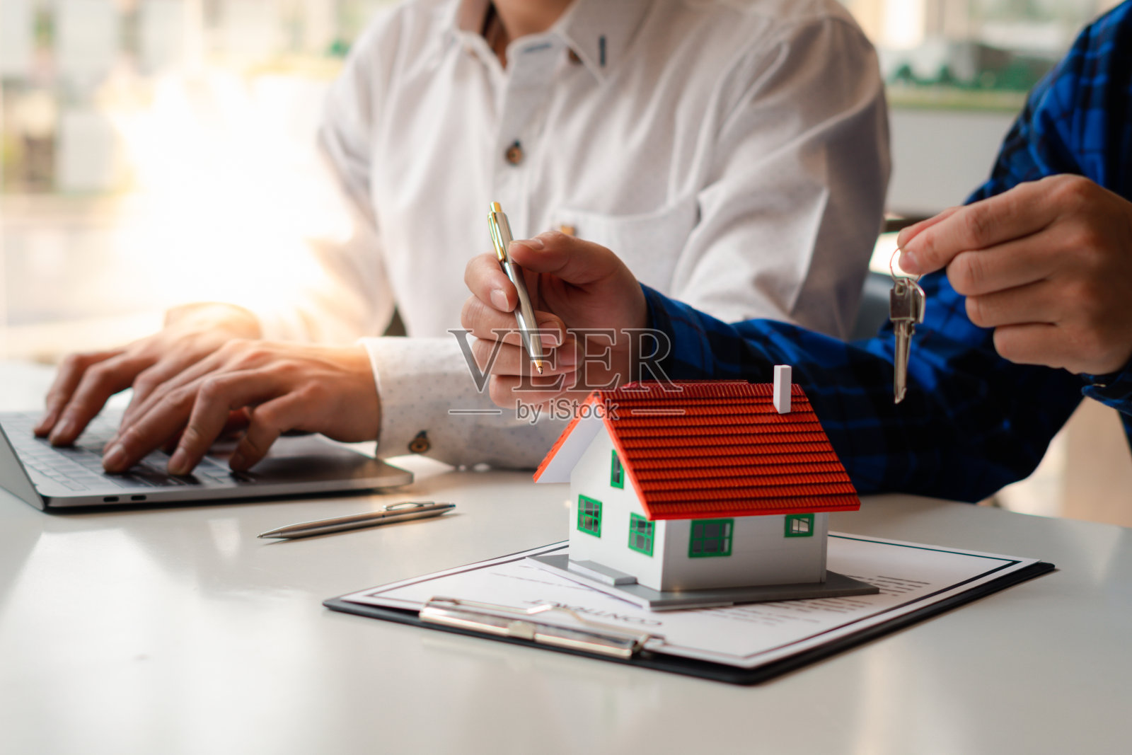 房地产经纪人正在向前来看房子设计和购买协议的客户解释房子的风格，按揭贷款批准，住房贷款和保险概念。照片摄影图片