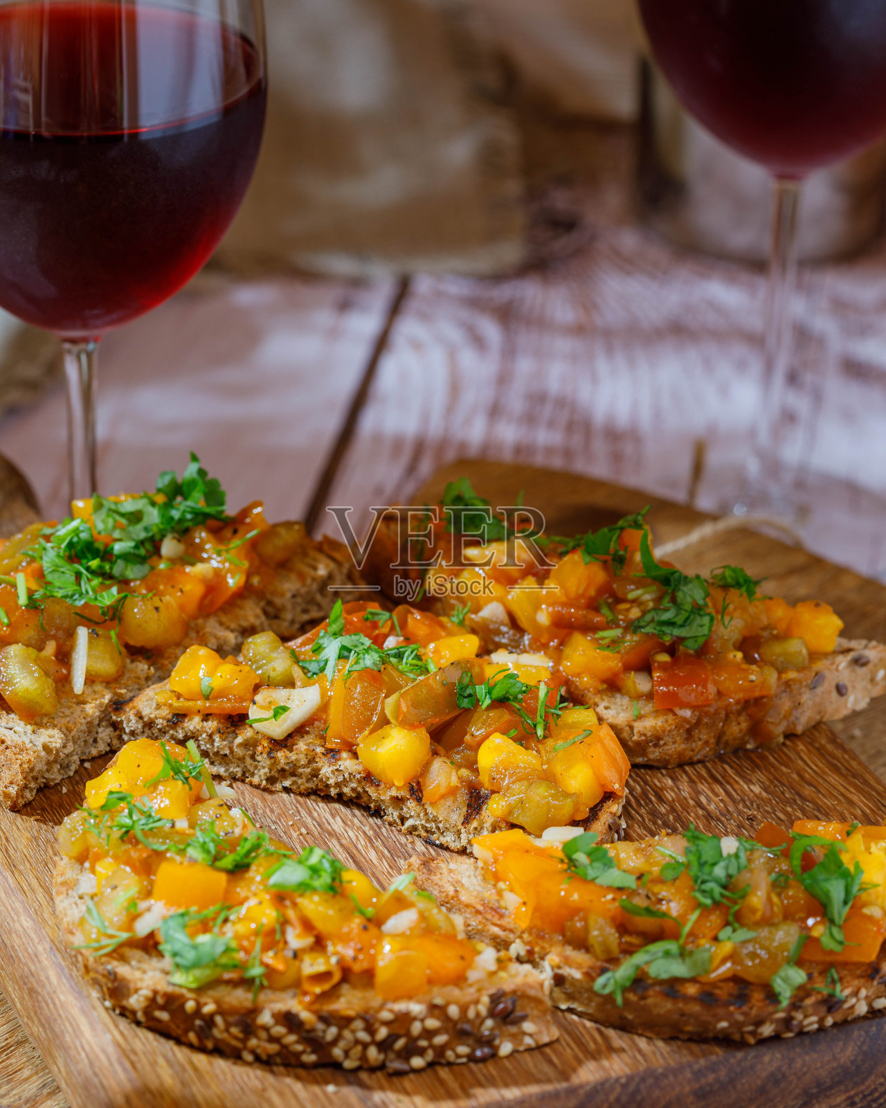 意式烤面包配橄榄酱和新鲜番茄放在切菜板上。木制背景。关闭了。照片摄影图片