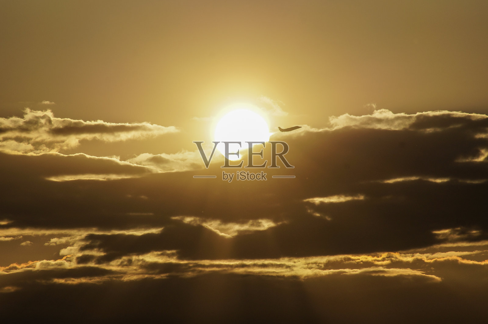 日落的云朵和一架飞机照片摄影图片