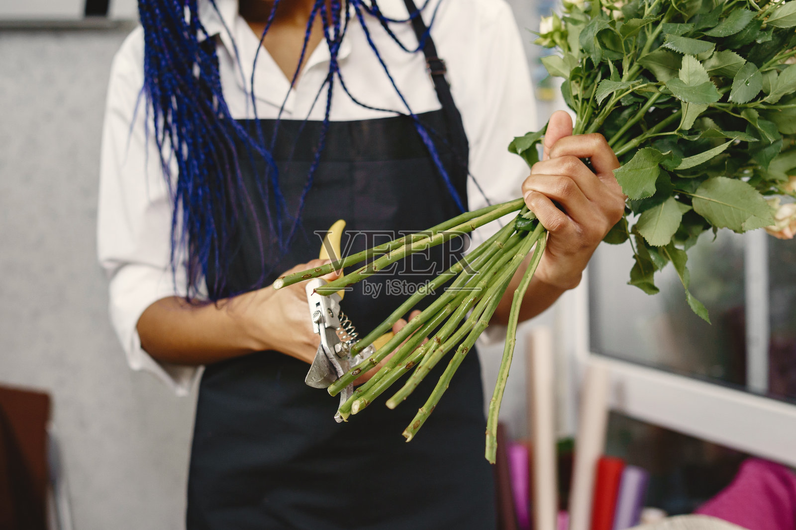 快乐的非洲裔美国年轻女子在花店的肖像照片摄影图片